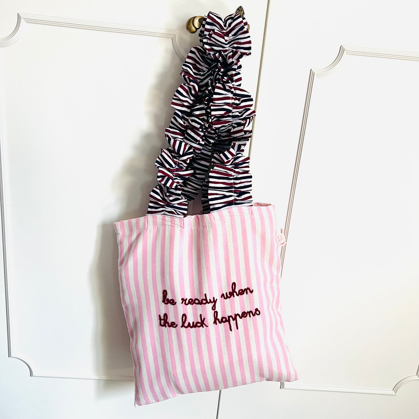 shopping bag in tela a righe rosa "be ready when the luck happens" ricamata a mano con manici volants