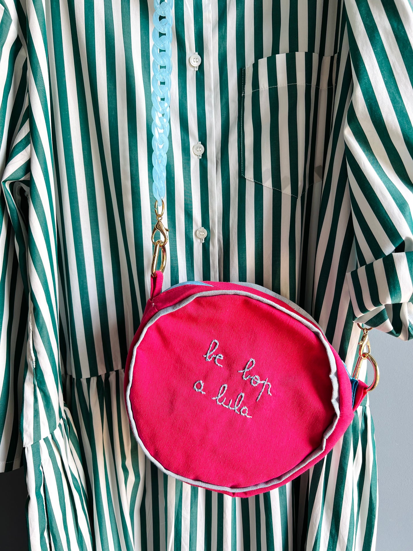 borsa a tracolla rotonda in tela fucsia " be bop a lula" ricamata a mano con profili in gros grain